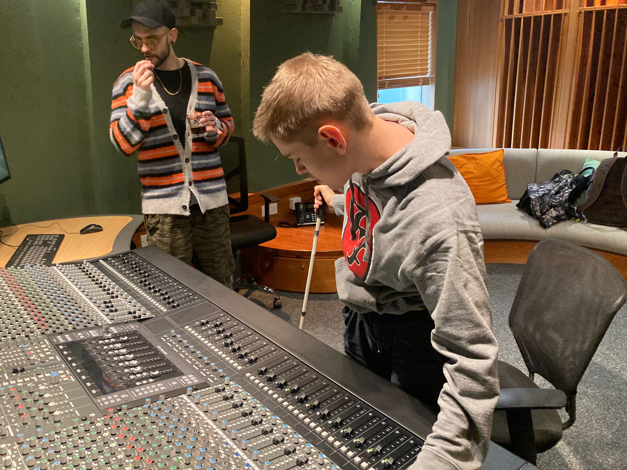 Marshall and an individual from the Solid State Logic team in front of the large SSL Origin, Analogue In-Line Console, listening to multi-track outputs while Marshall makes adjustments with the levels knobs.